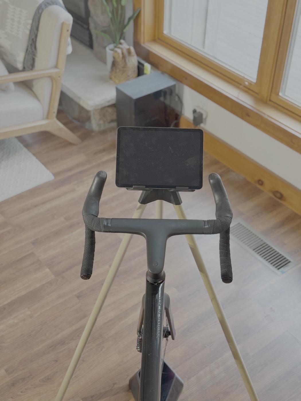 Faster Stands tablet stand positioned in front of an indoor bike.