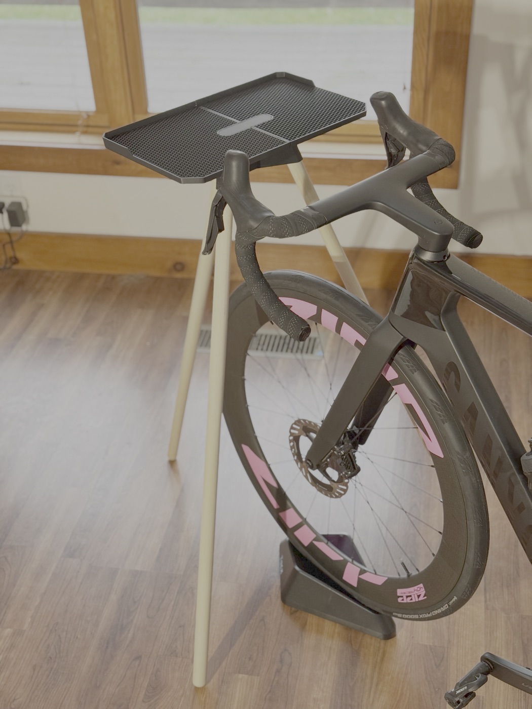 Faster Stands laptop stand positioned beside an indoor bike.